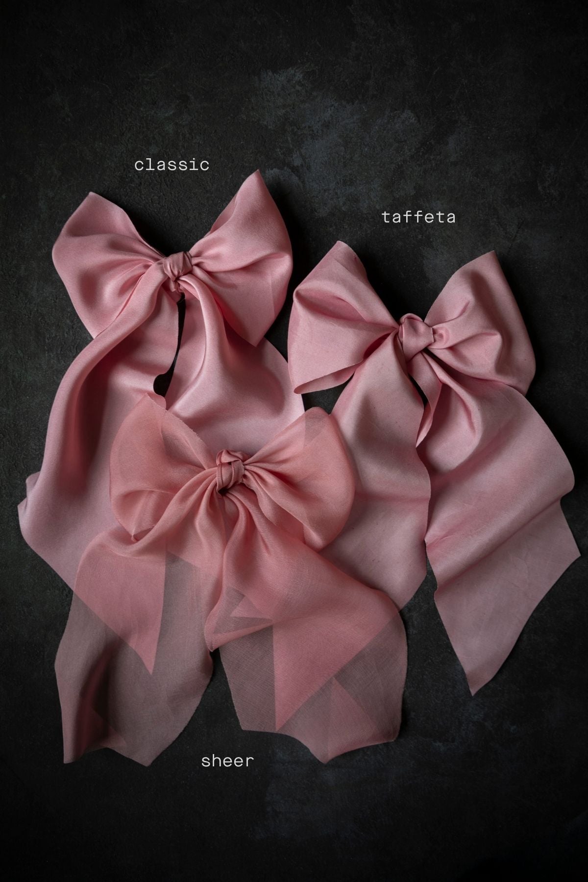 Three pink fabric bows labeled 'classic', 'taffeta', and 'sheer' on a dark background.