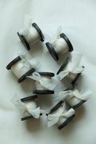 antique white organza silk ribbon on antique wood spool, displayed on white background