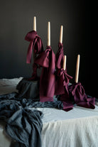 Decorative candles with ribbons on a table with draping textiles