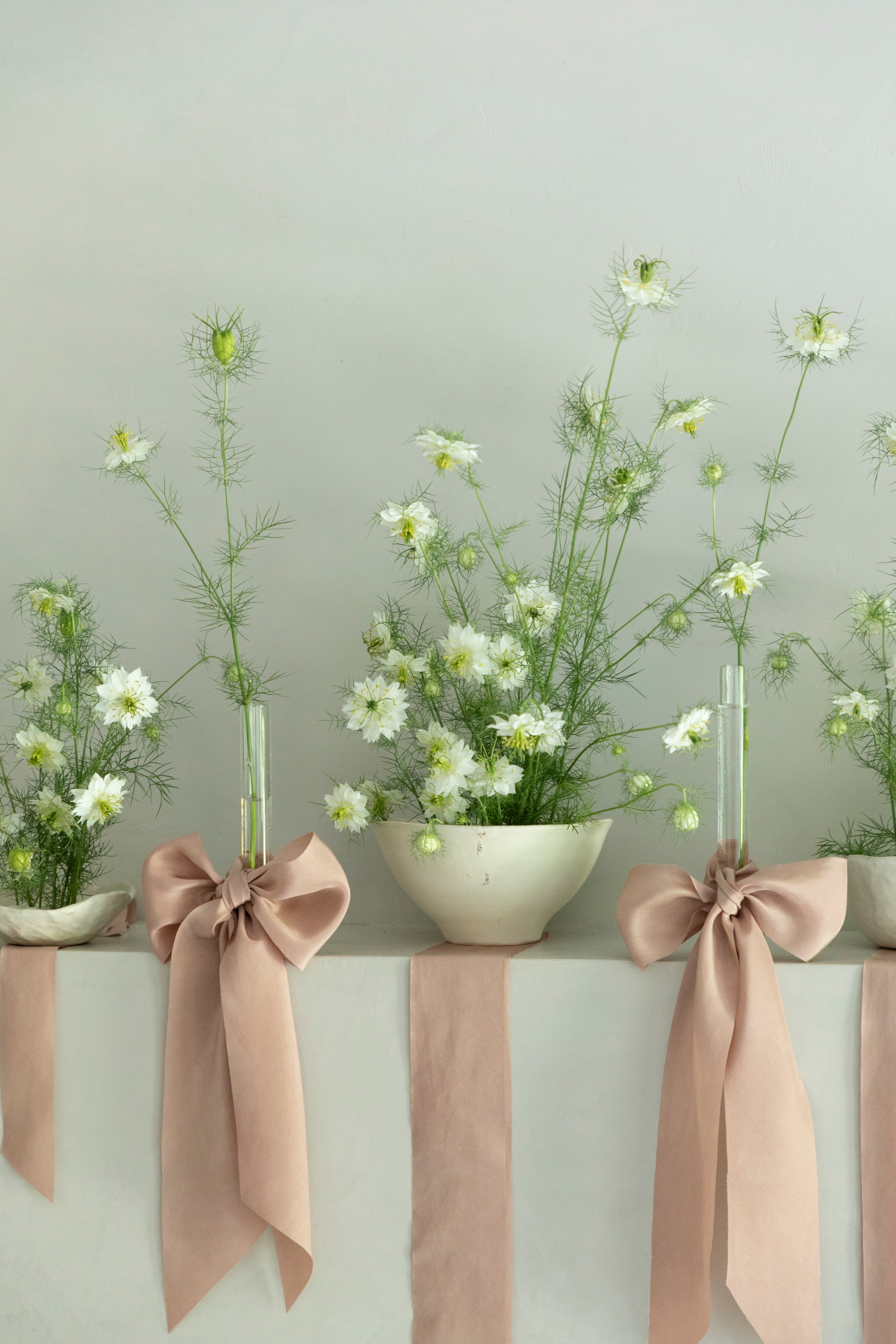 floral centerpiece with white handmade ceramics and pink ribbon bows