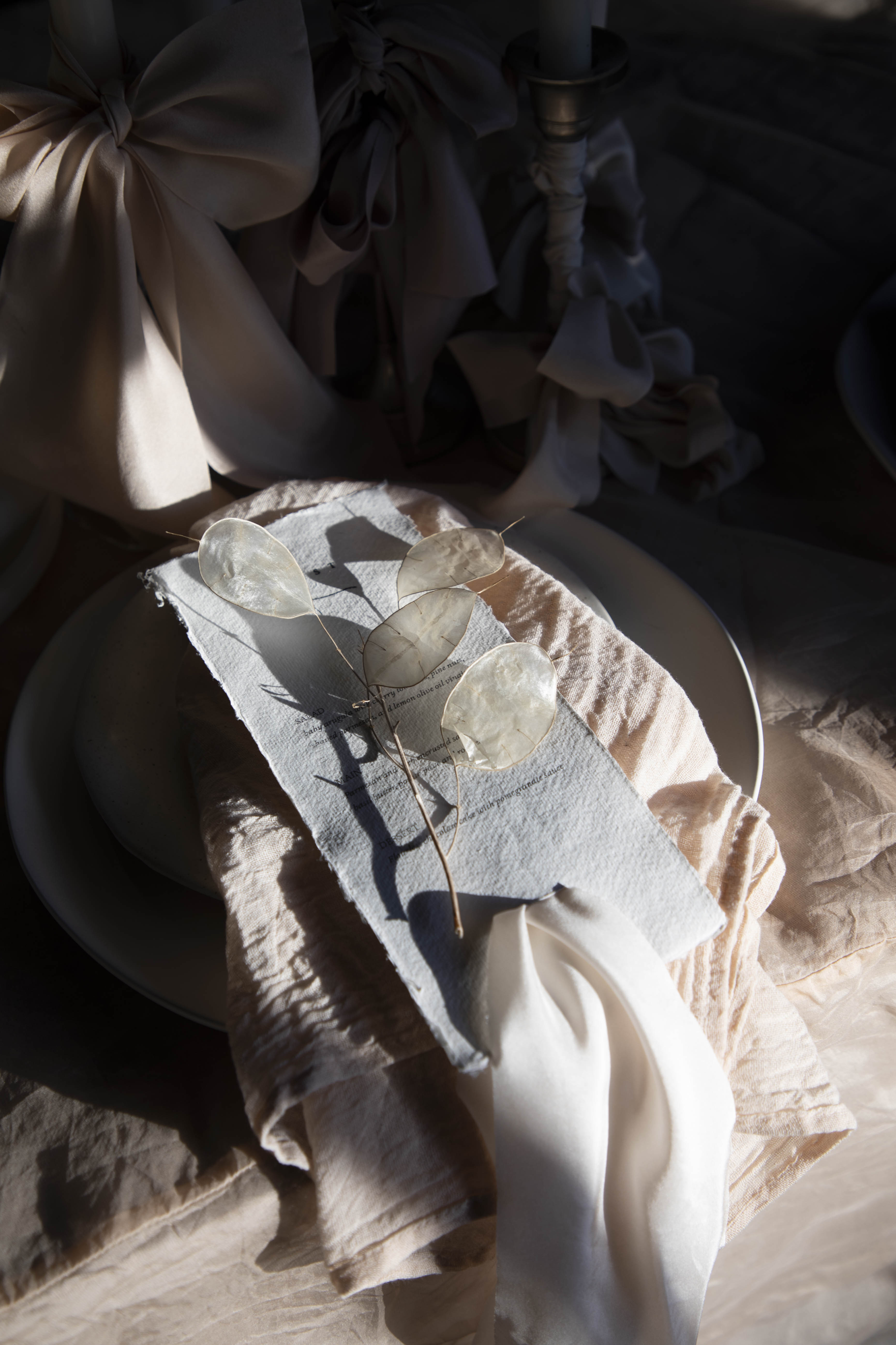Decorative table setting with a napkin featuring butterfly design on a textured surface.