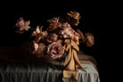 floral centerpiece on a wedding table with draped textiles with a dark background