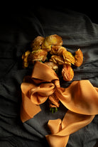 Orange ranunculus flower arrangement with orange silk ribbon