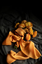 Orange ranunculus flower bouquet with orange silk ribbon