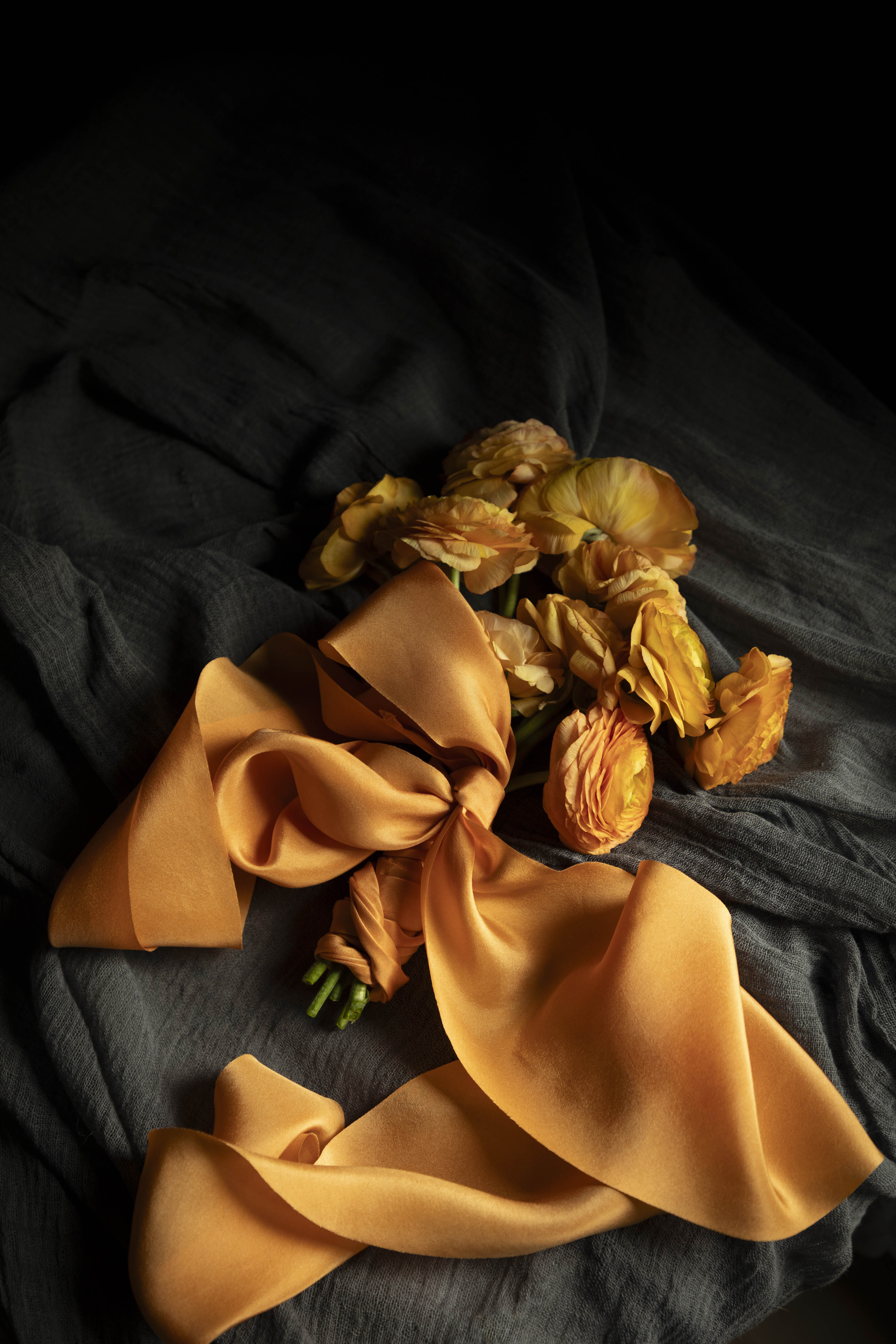Orange ranunculus flower bouquet with orange silk ribbon