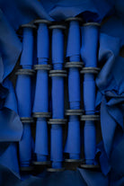 Blue fabric rolls stacked together with a dark blue background