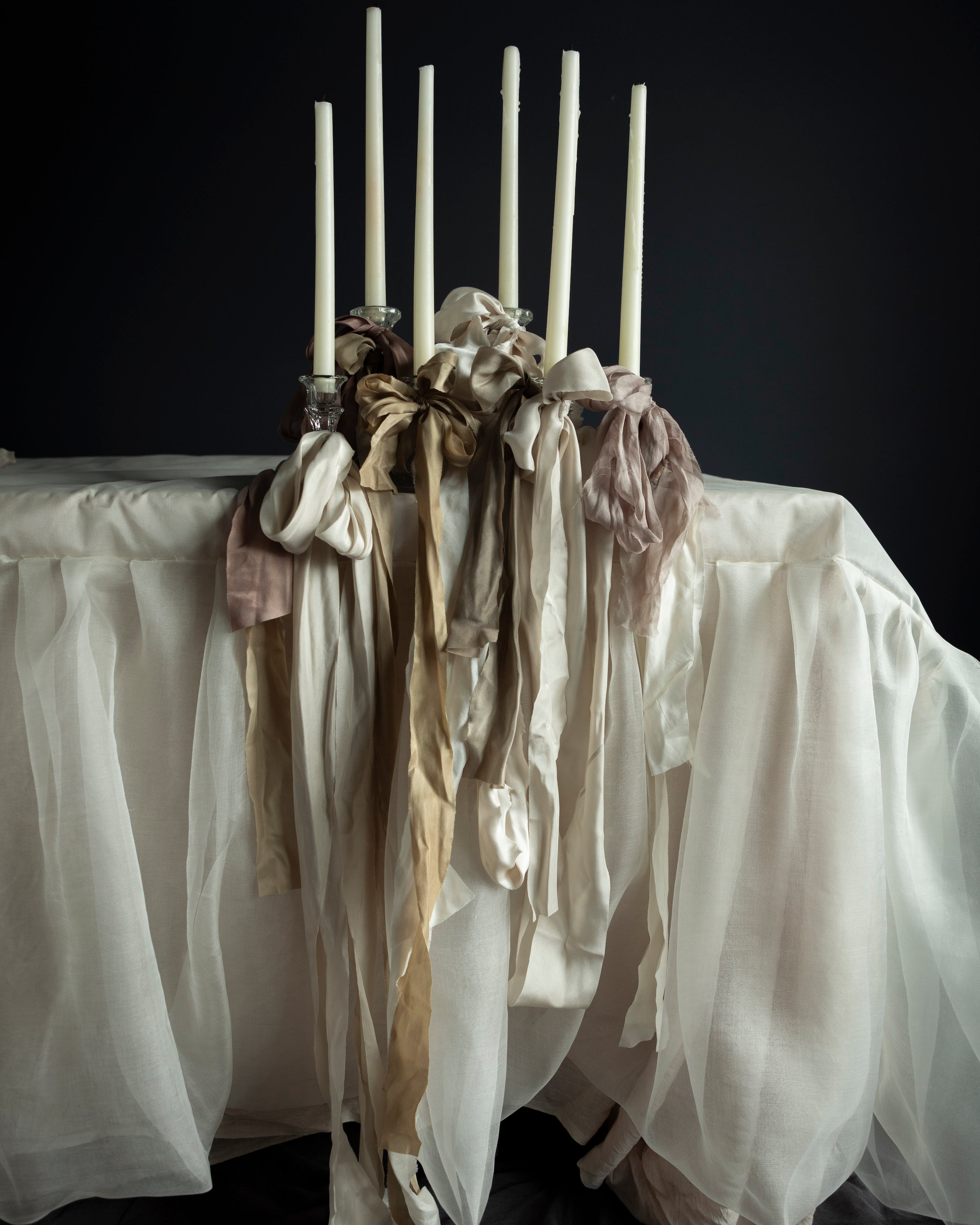 Silk & Willow ribbon stacking experts. White silk wedding table with candles with ribbon stacking