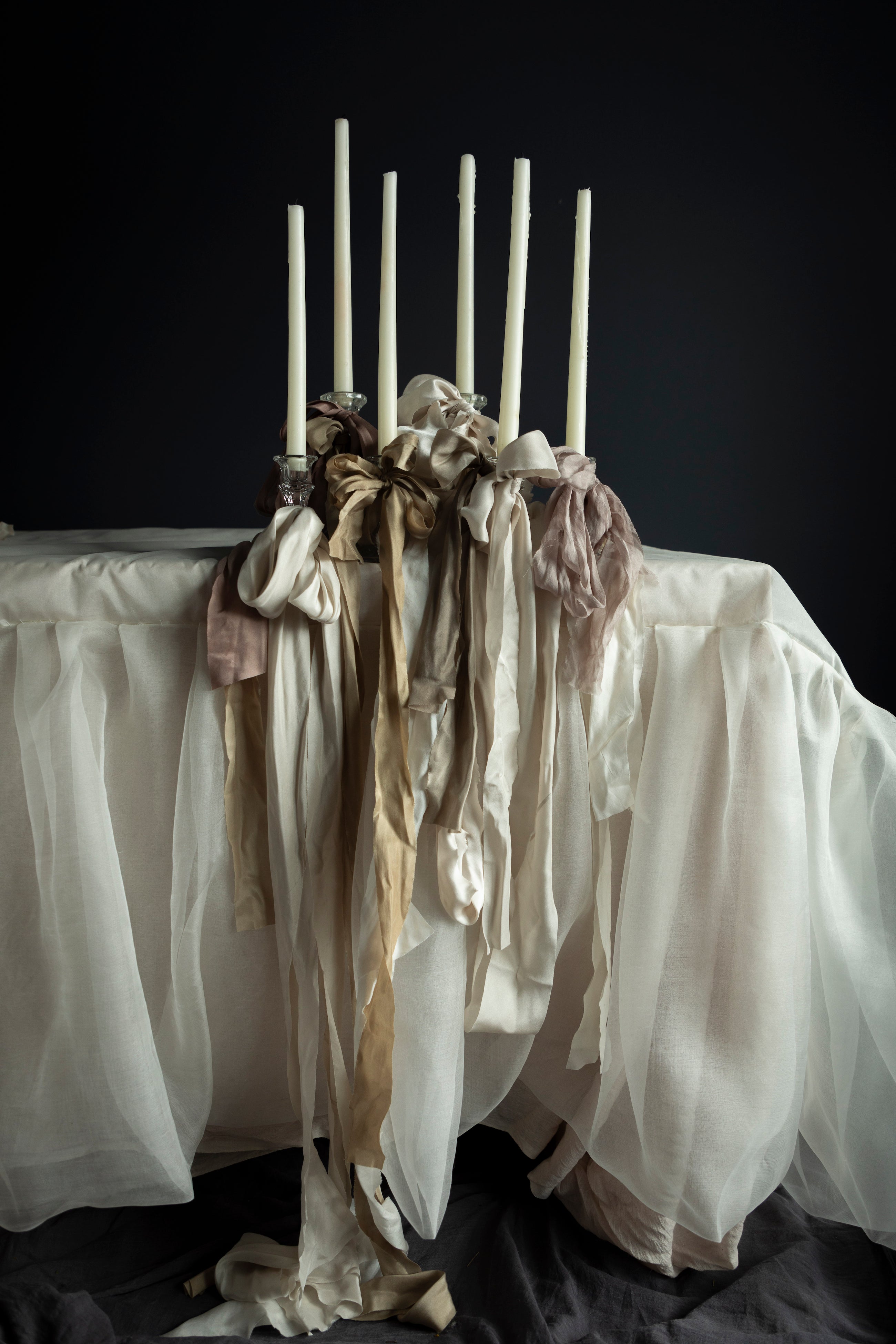 Silk & Willow ribbon stacking experts. White silk wedding table with candles with ribbon stacking