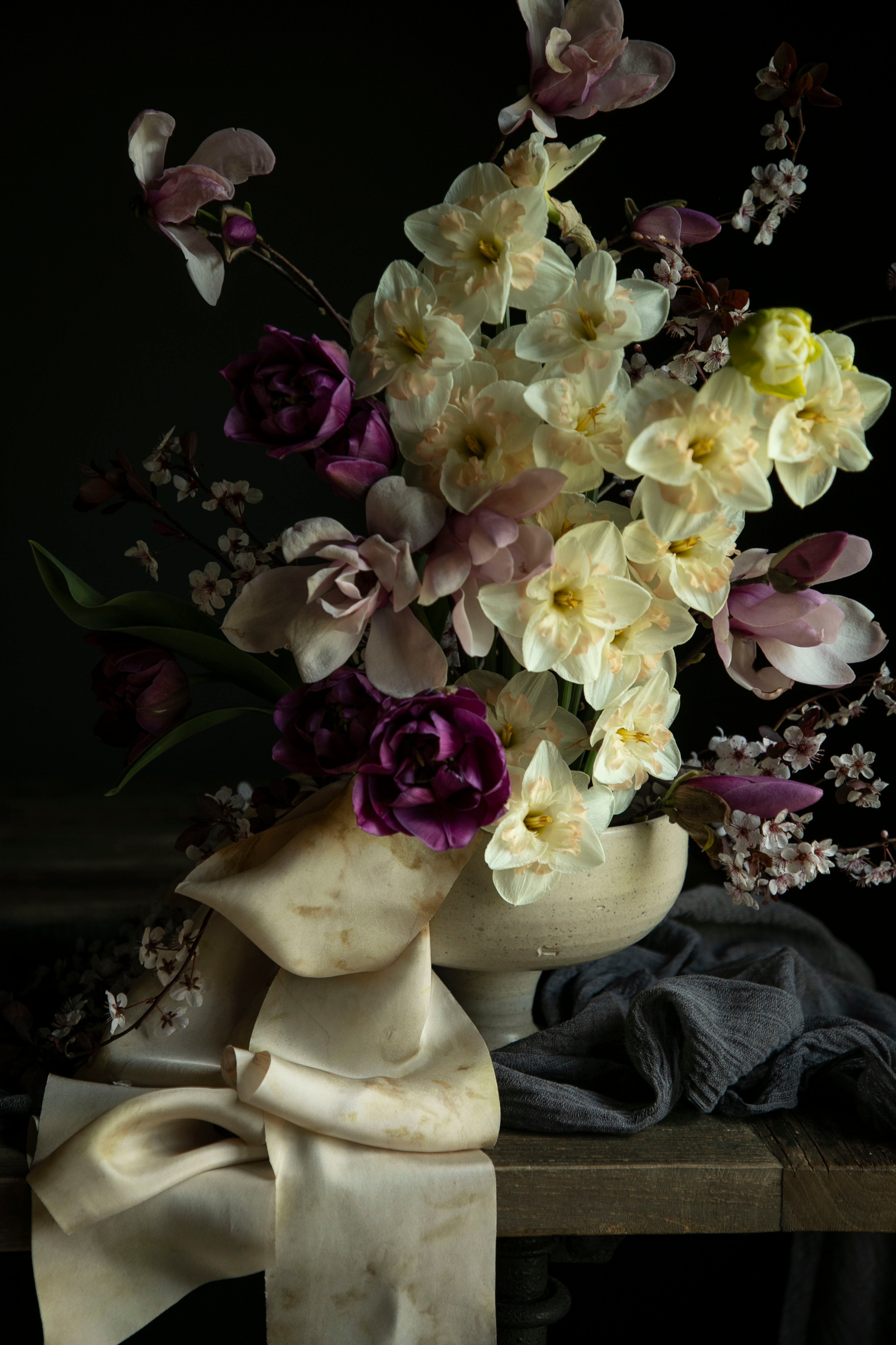 Floral arrangement in a marble vase on a dark background
