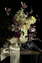 Floral arrangement in a sculpture-like vase on a dark background