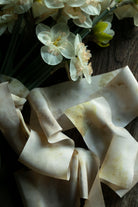 Bouquet of white flowers with a crumpled white paper or fabric on a wooden surface.