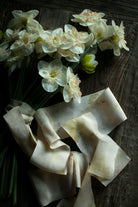 White flowers and ribbons on a wooden surface