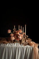 Decorative table setting with flowers, candles, and a dark background