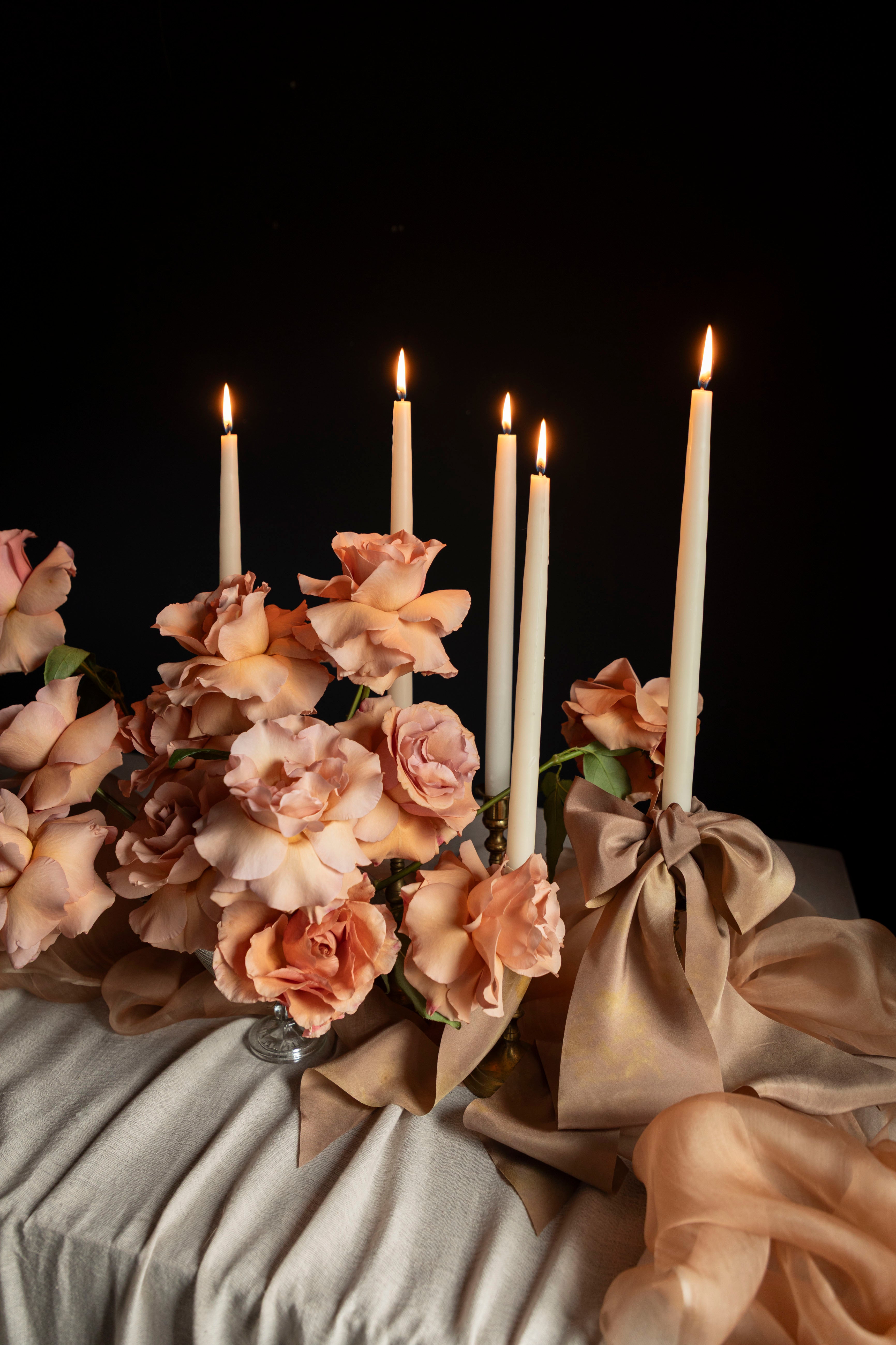 Decorative arrangement with candles and flowers on a dark background