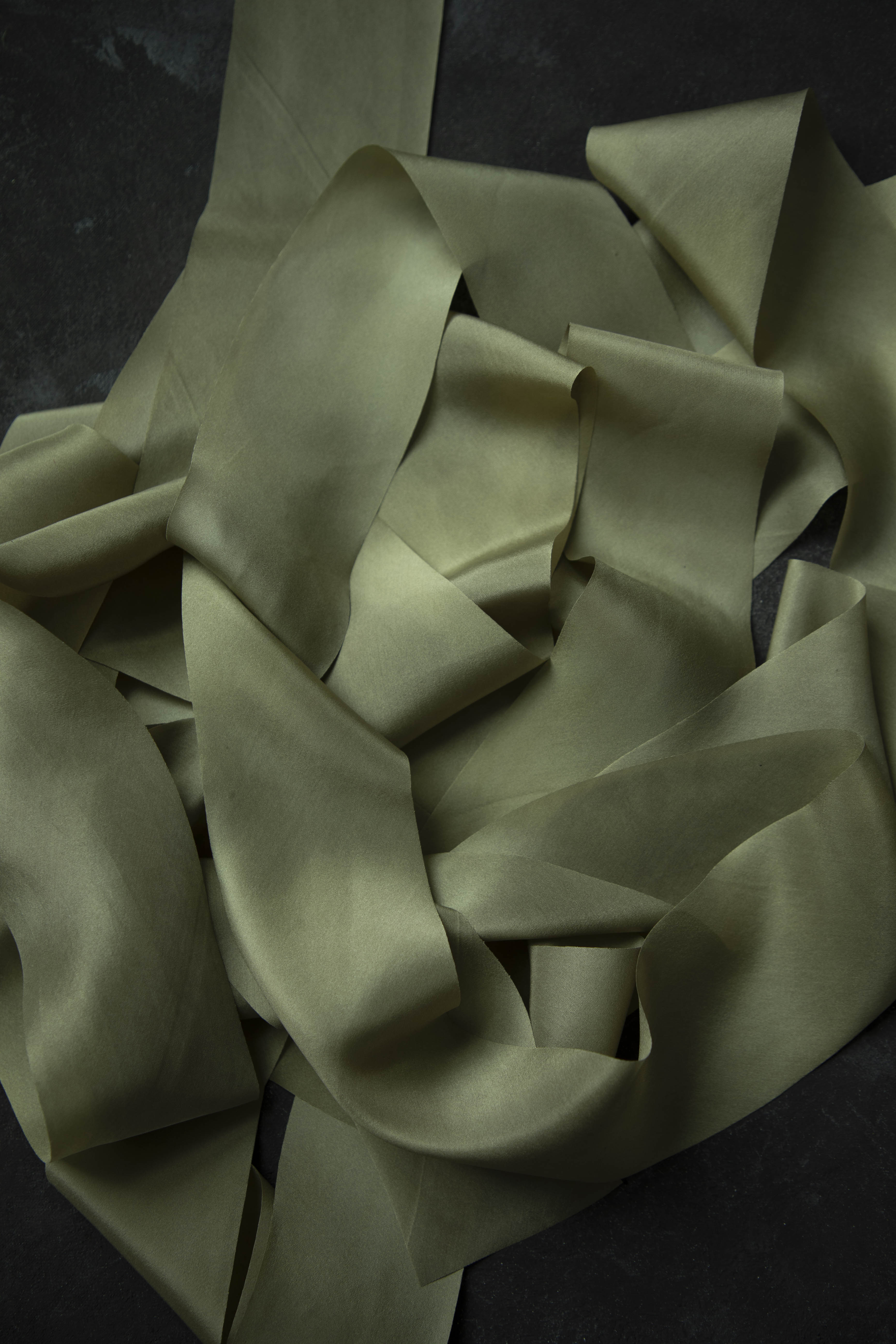 Folded light green fabric on a dark background