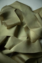 pile of green silk ribbons on a white background