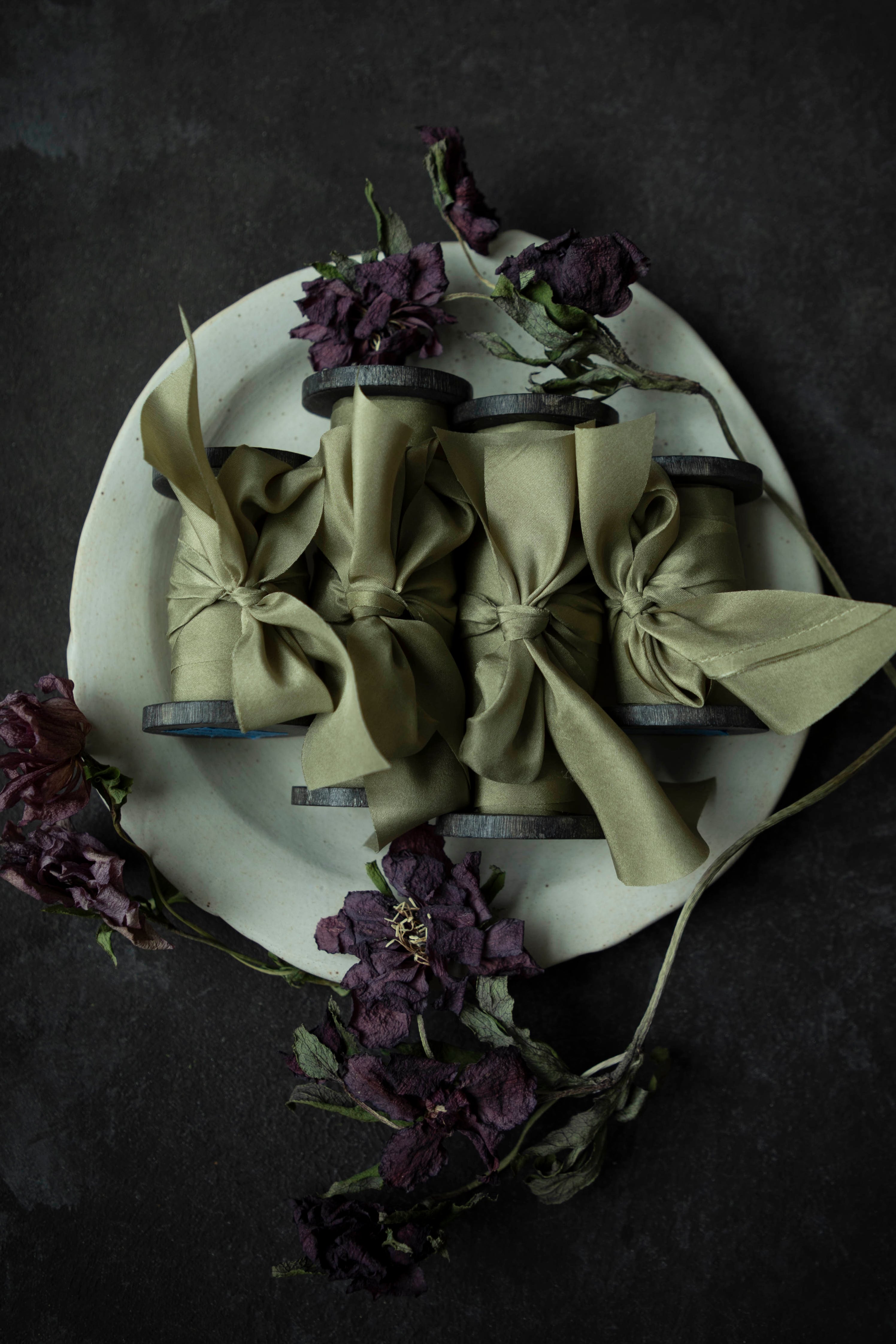 premium green ribbons set on a white ceramic plate with decorative flowers