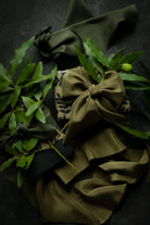 Green fabric with a bow and leaves on a dark background