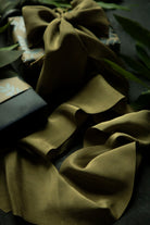 Green fabric with a bow on a gift and on a dark background