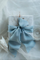 French blue bow on a white box with a white background. luxury giftwrapping