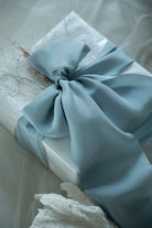 French blue bow on a white box with a textured background. Luxury gift wrapping inspiration