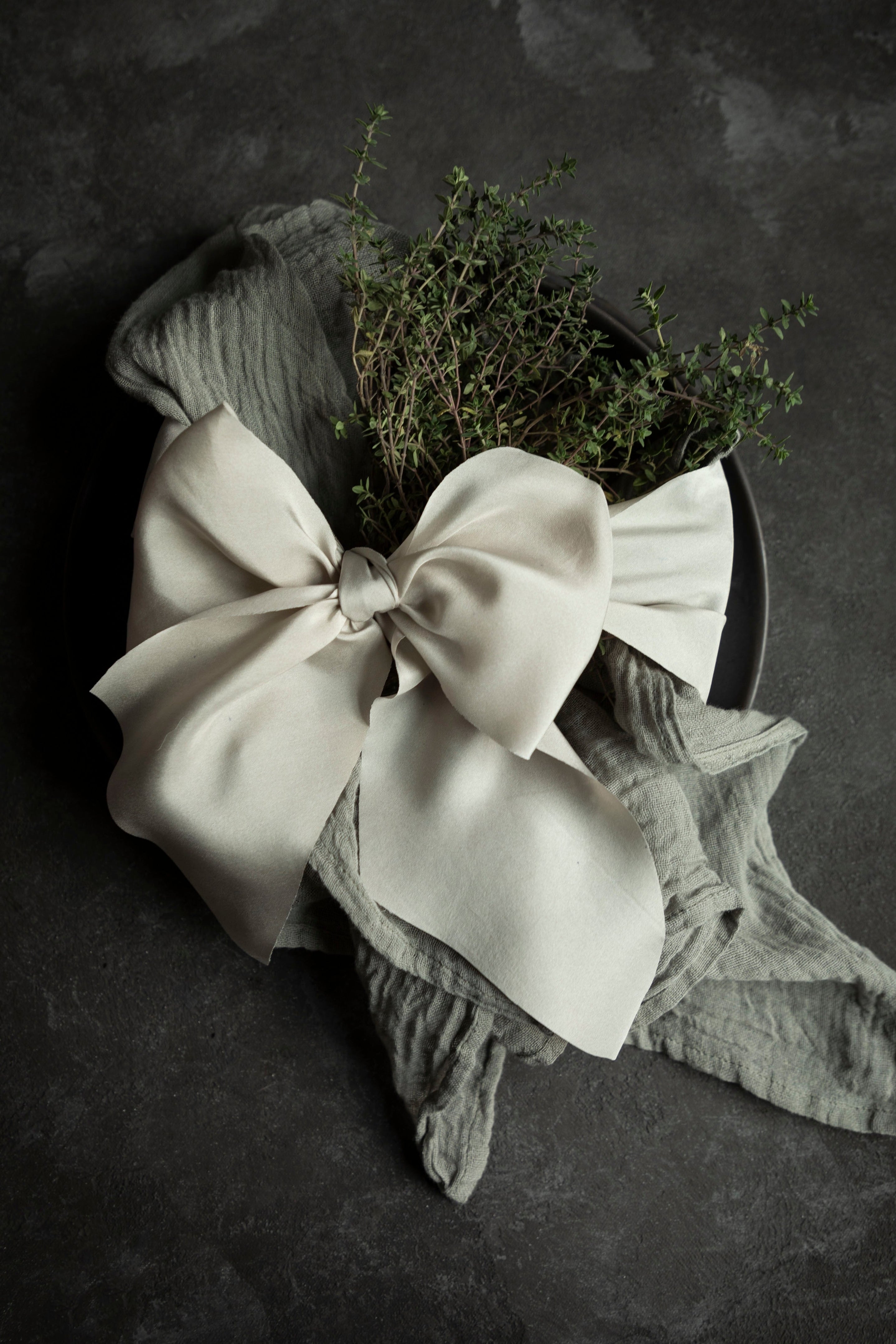 Floral arrangement with a large bow on a dark background