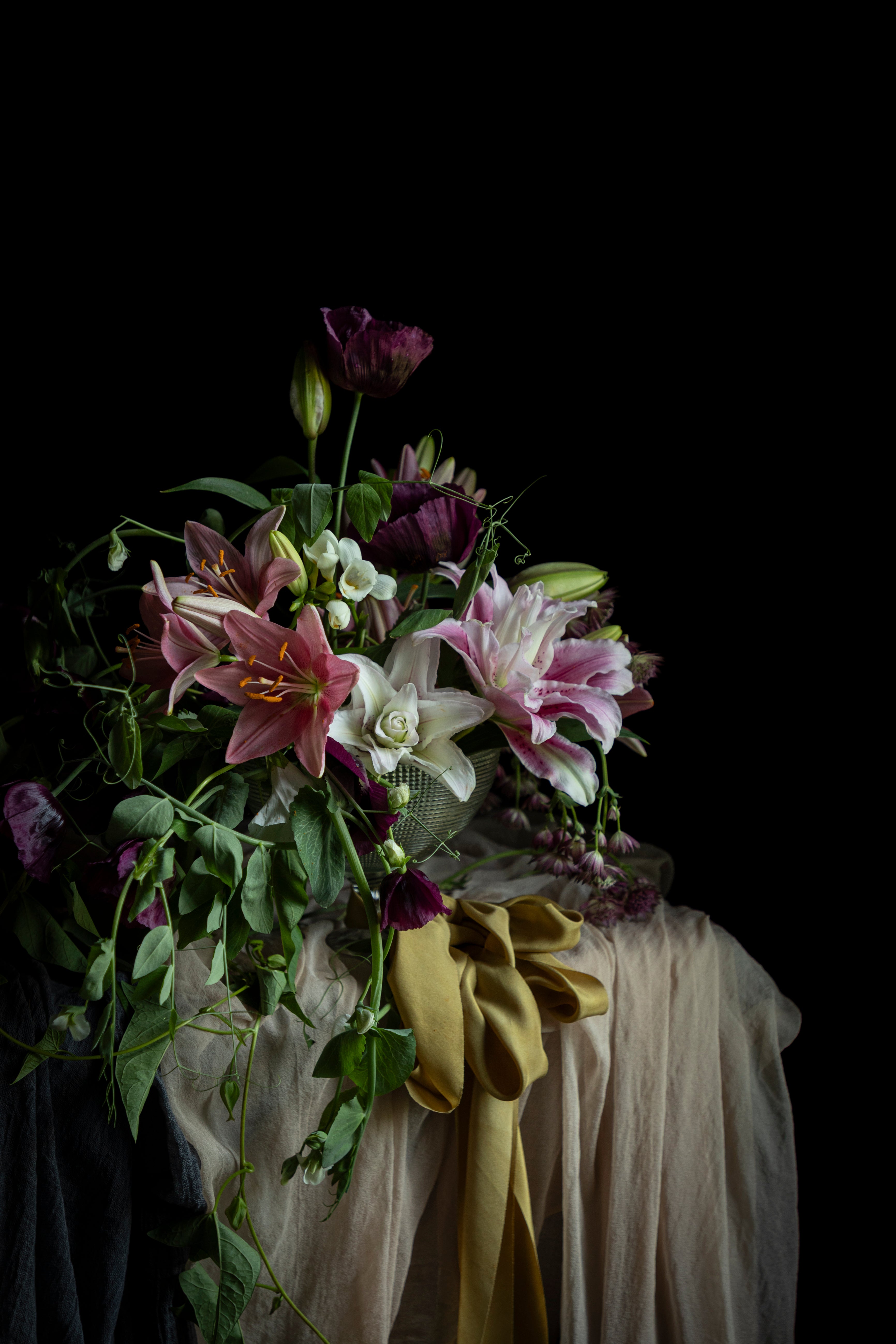 Floral arrangement with a green ribbon on a dark background