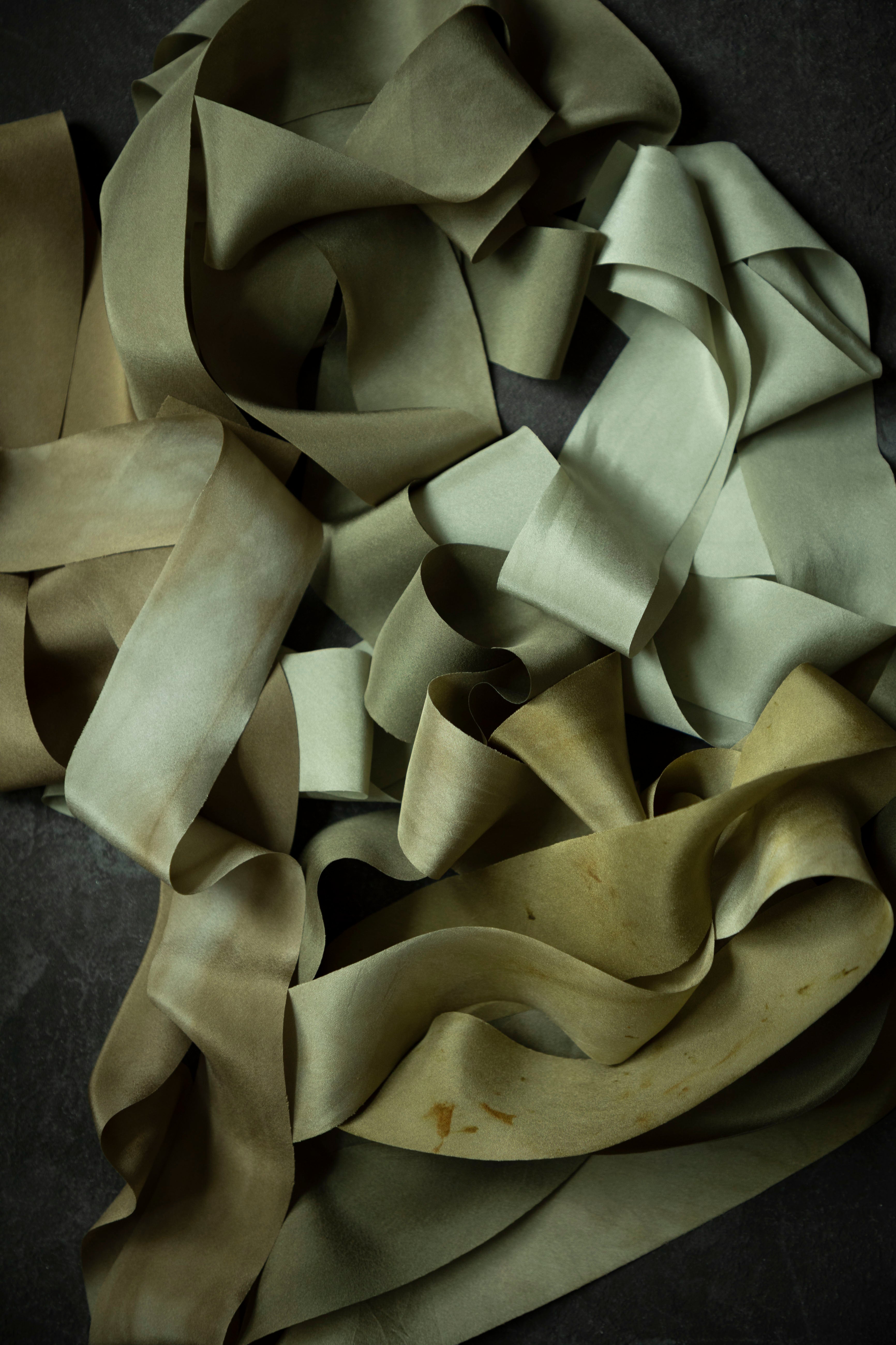 pile of premium green silk ribbon on a dark background