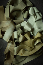 pile of premium green silk ribbon on a dark background