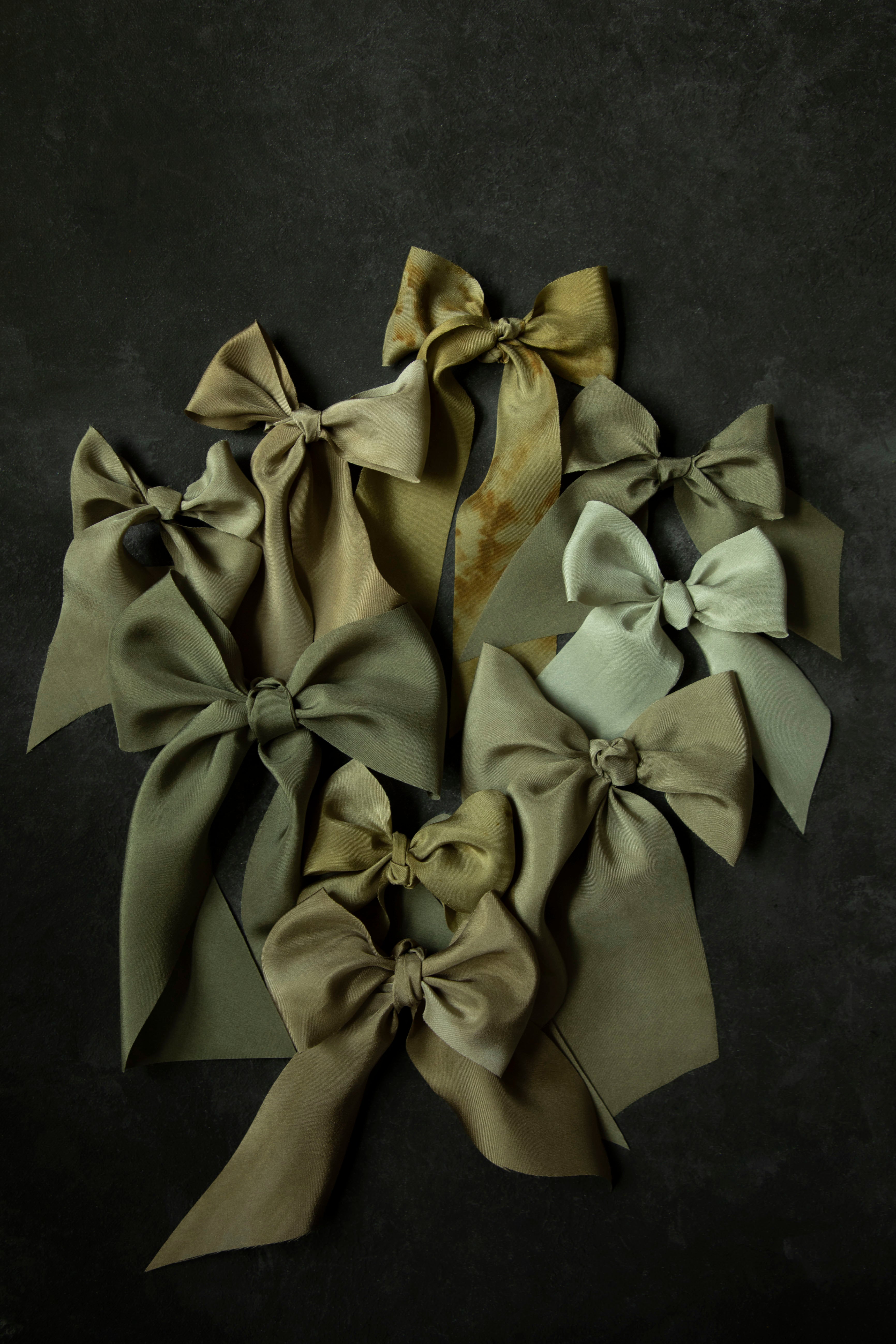 Set of green and beige hair bows on a dark background