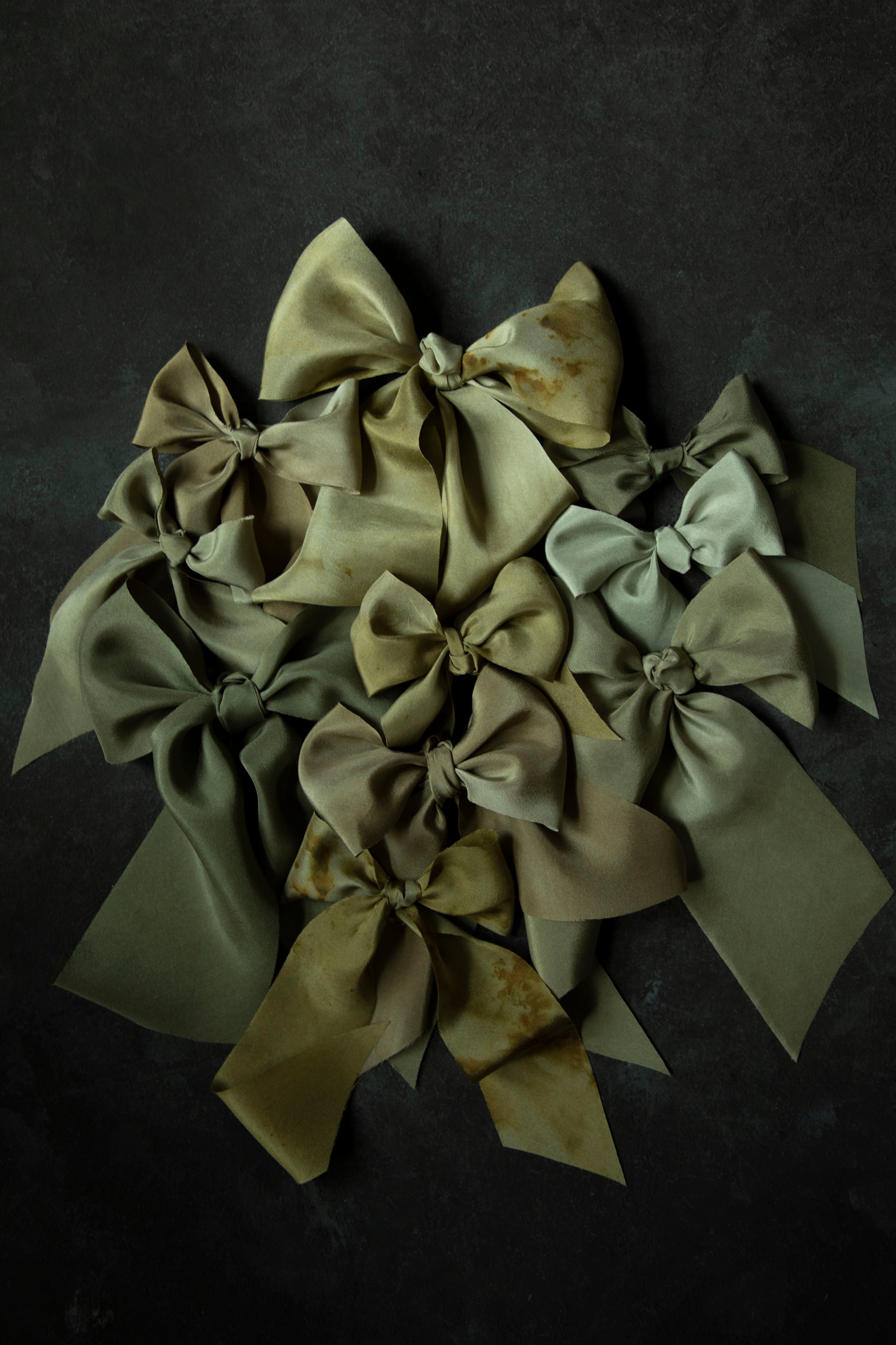 Collection of green silk ribbon bows on a dark background