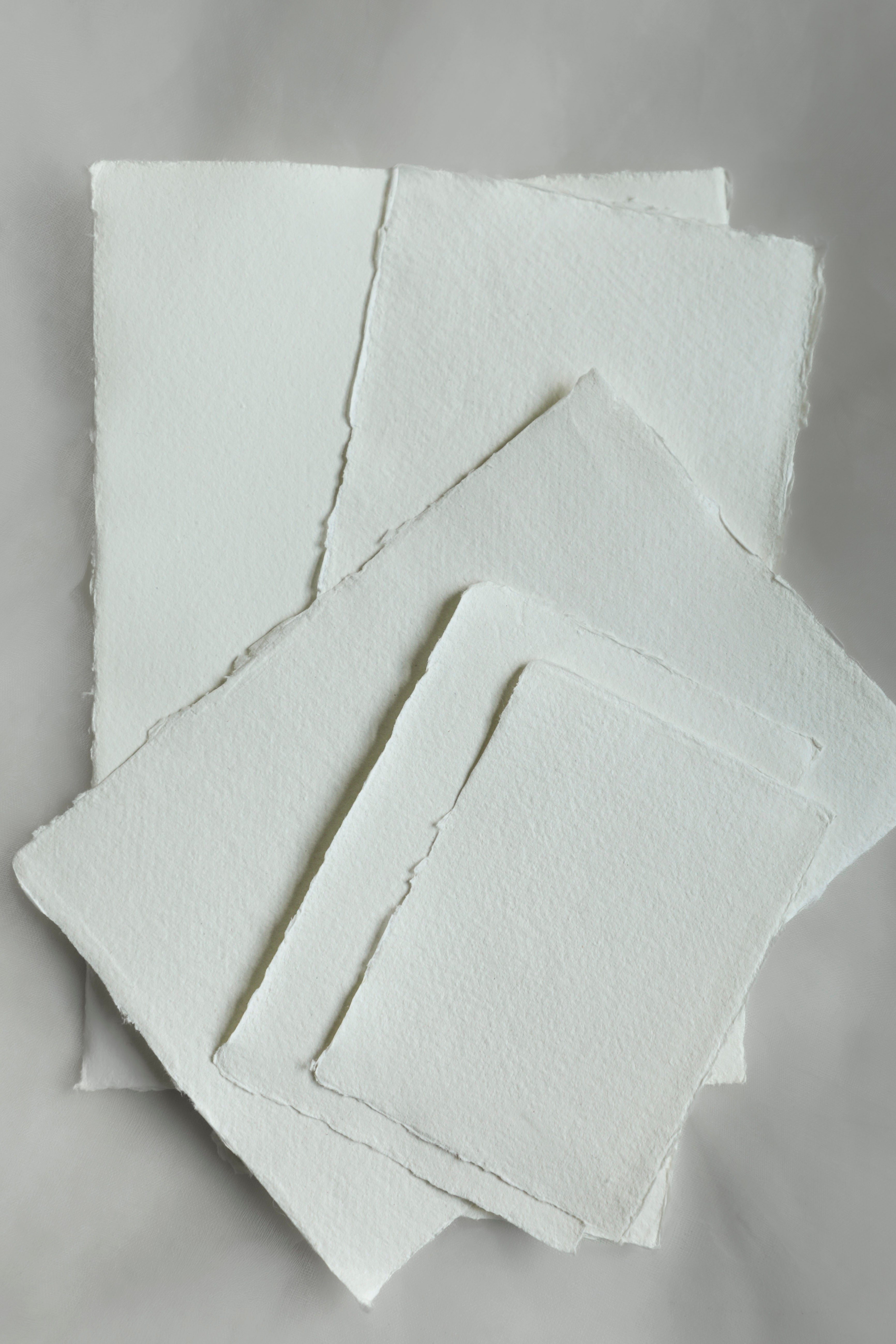 Stack of white textured paper sheets on a gray background