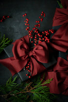 Black gift box with a red ribbon and berries on a dark background