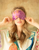 A model wearing a luxurious silk sleep mask adorned with delicate, nature-inspired botanical patterns. The mask exudes a fresh and restorative feel, combining elegance and comfort—a perfect addition to the Anthropologie aesthetic.