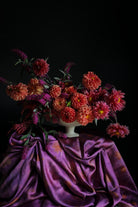 hot peony silk scarf used as a styling silk draped on a table with a dahlia flower floral arrangement