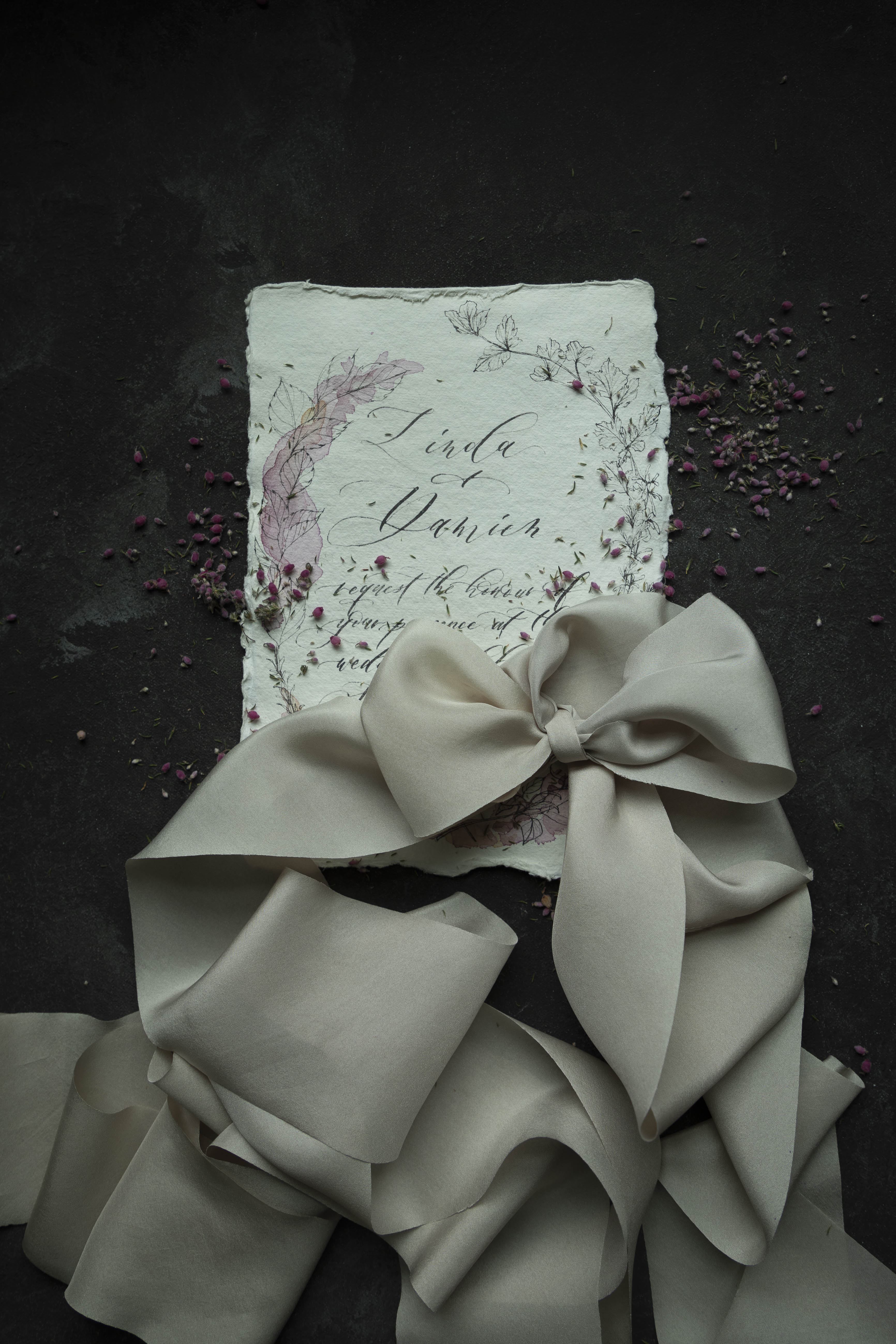 custom wedding invitation tied with a silk ribbon bow