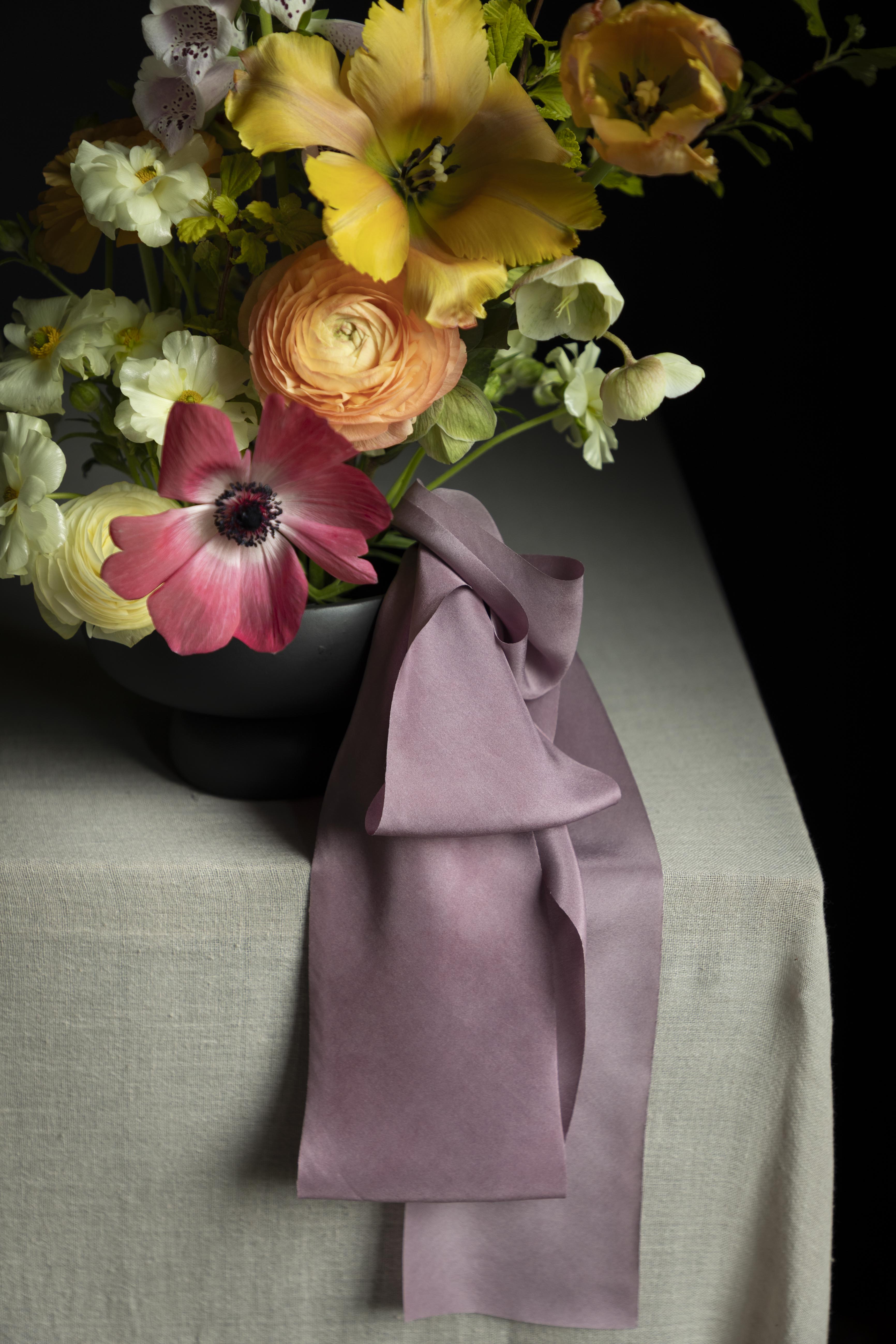 closeup of modern floral design for weddings. Purple silk ribbon accent