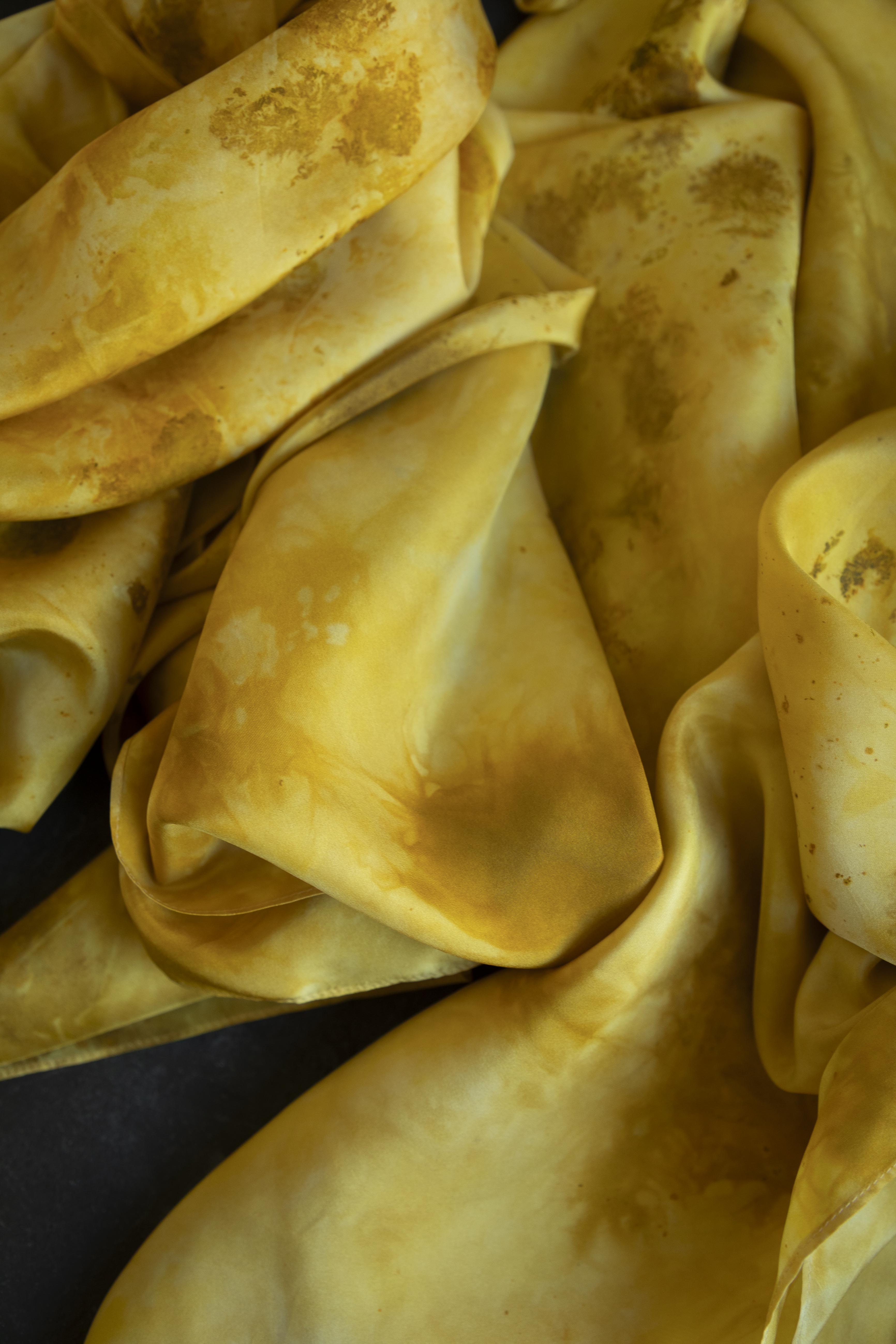 Close-up of yellow fabric with visible stains and discoloration