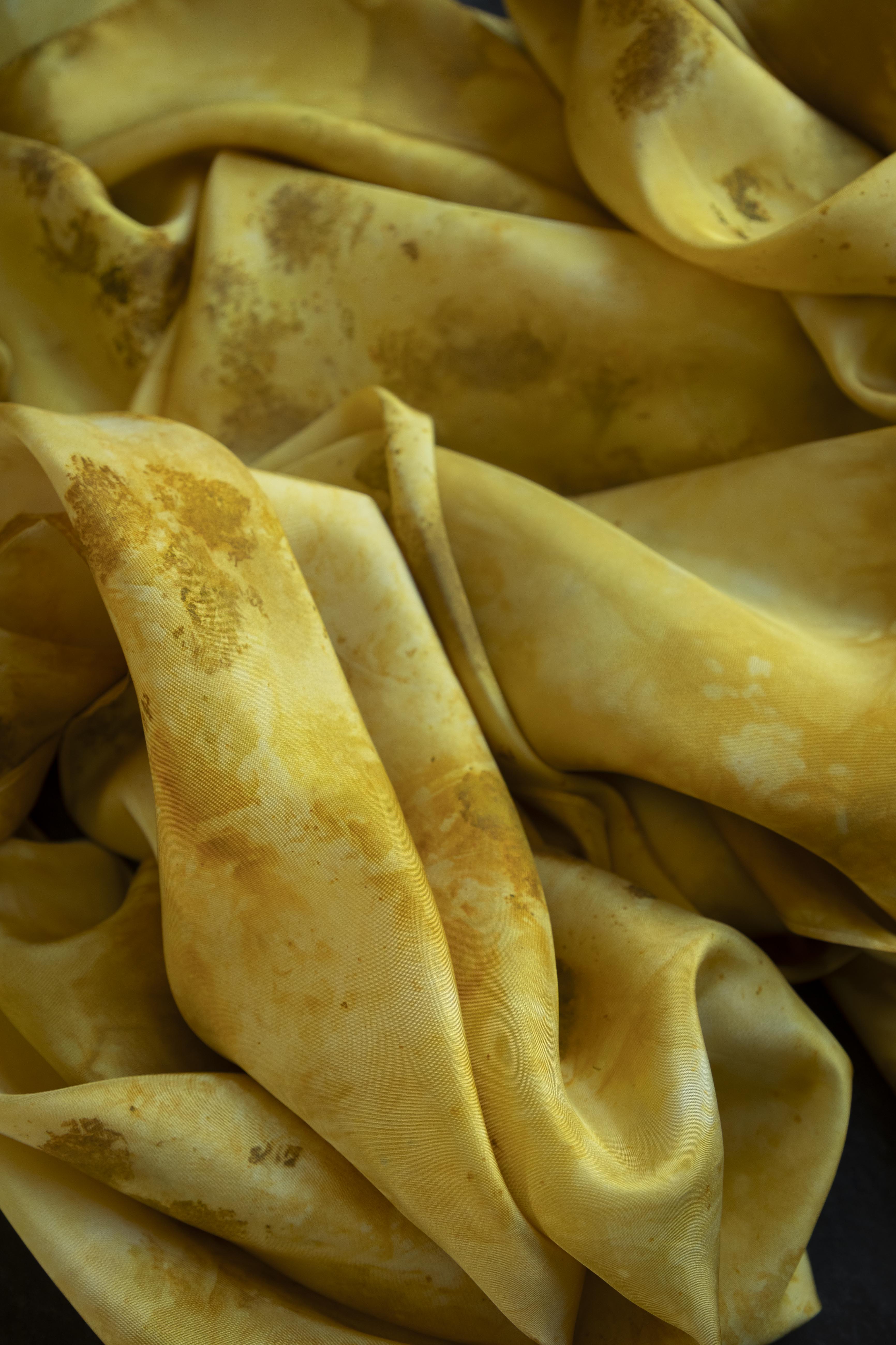 Yellow fabric with brown stains and discolorations