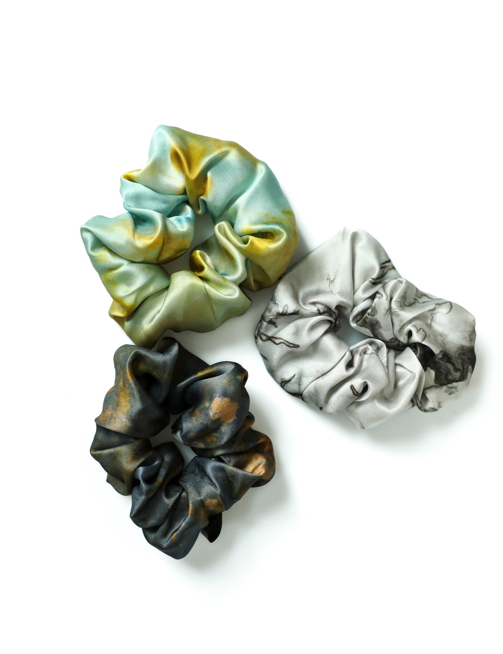 Three colorful scrunchies on a white background