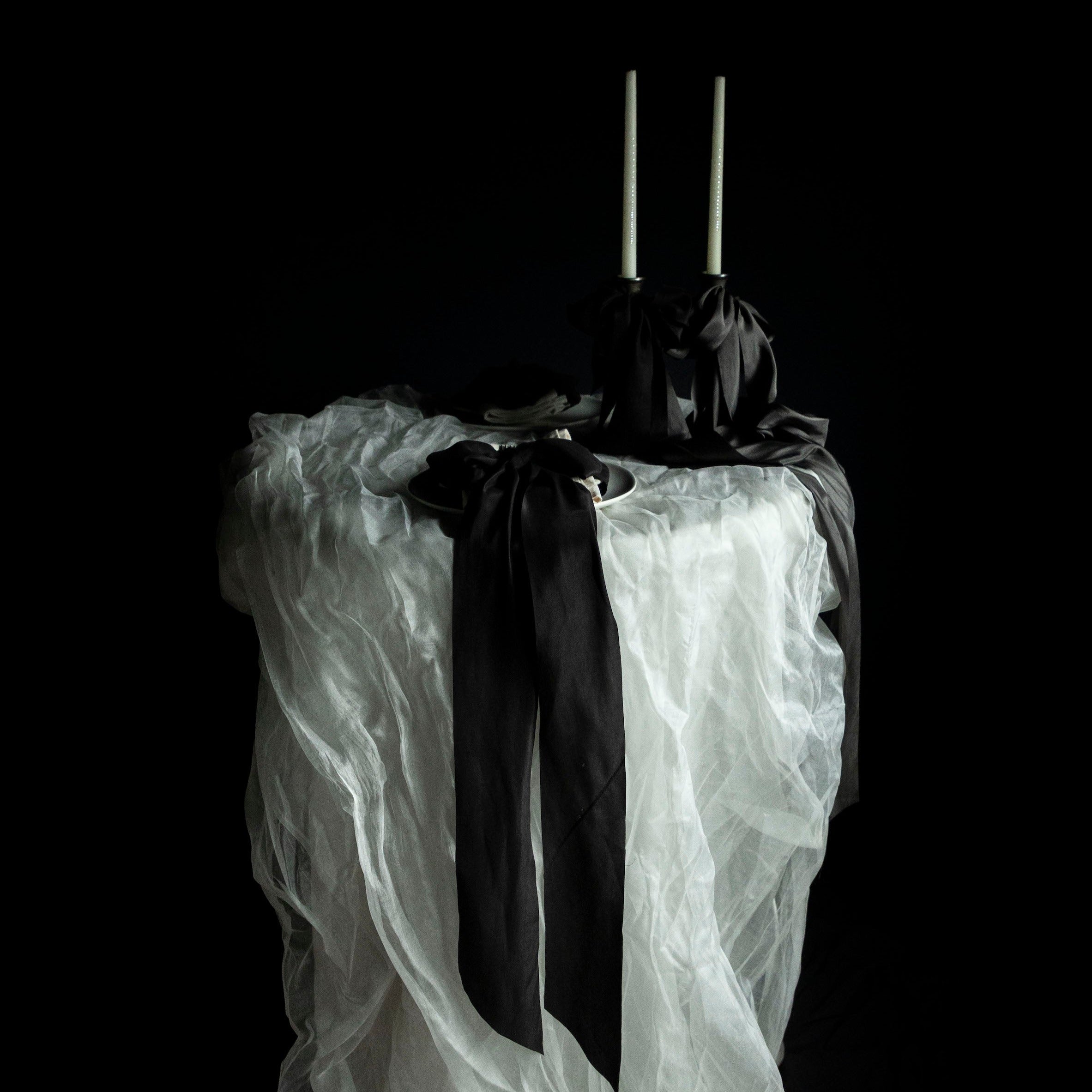 tablescape design. Wedding table with flowing white silk and black bow details