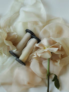 Vintage-style sewing tool on a soft fabric background