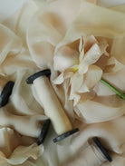 Spool of sheer ribbon on a fabric background with black wood spools