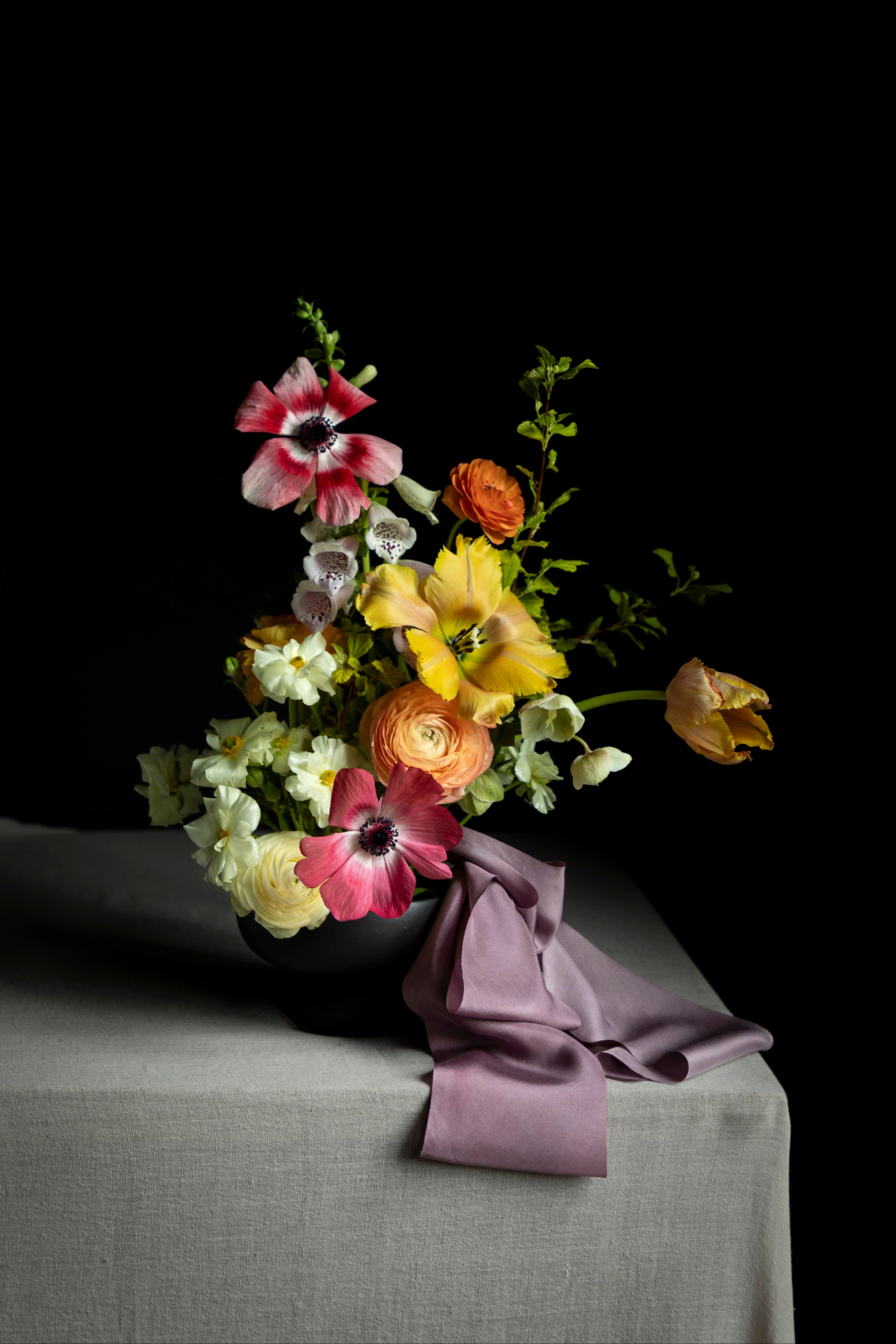 flowers in a black ceramic bowl with silk ribbon decoration