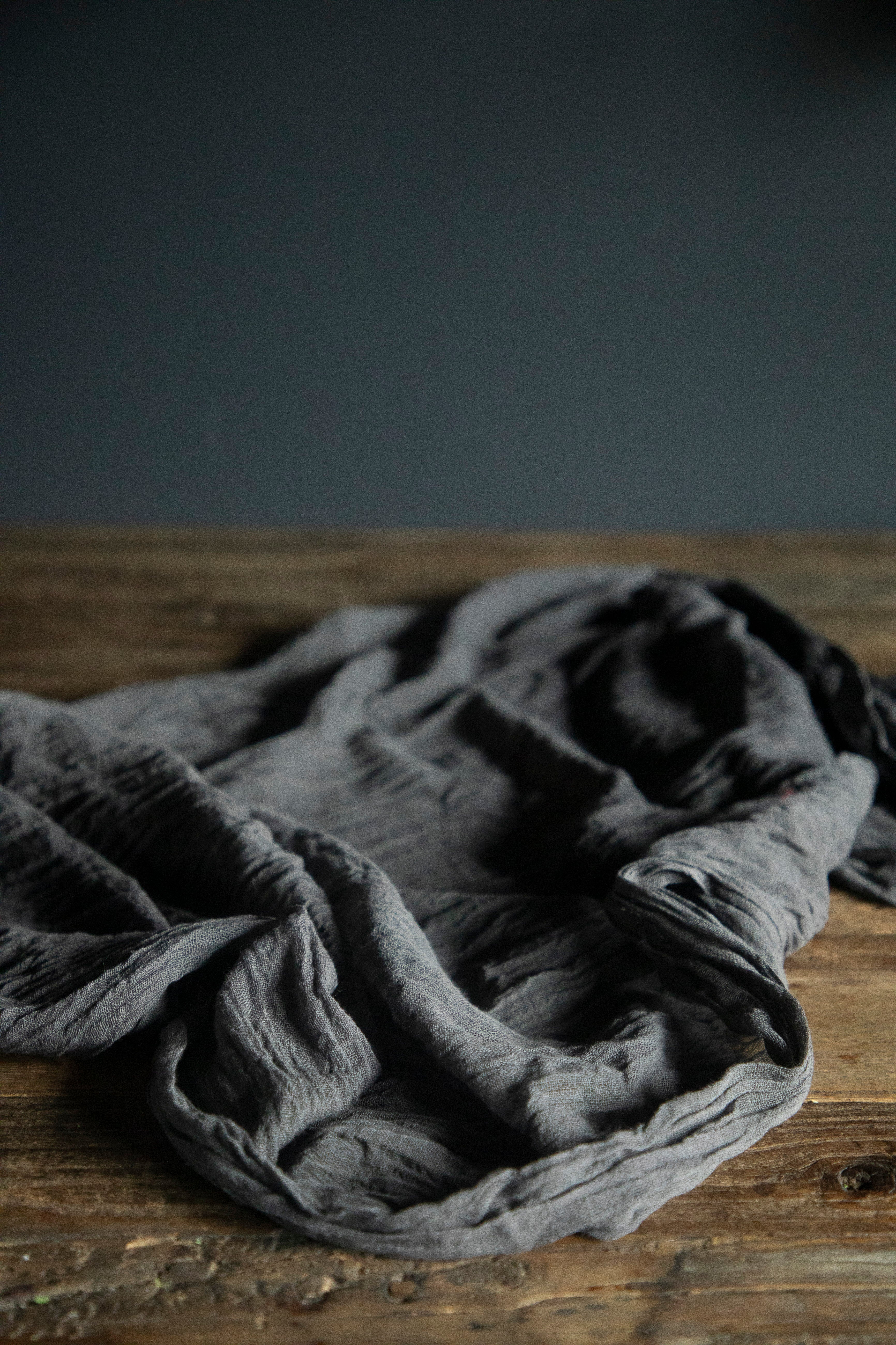 Gray fabric on a wooden surface with a dark background