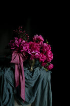 Bouquet of pink flowers with a pink ribbon on a dark background. Unique wedding trends 2027.