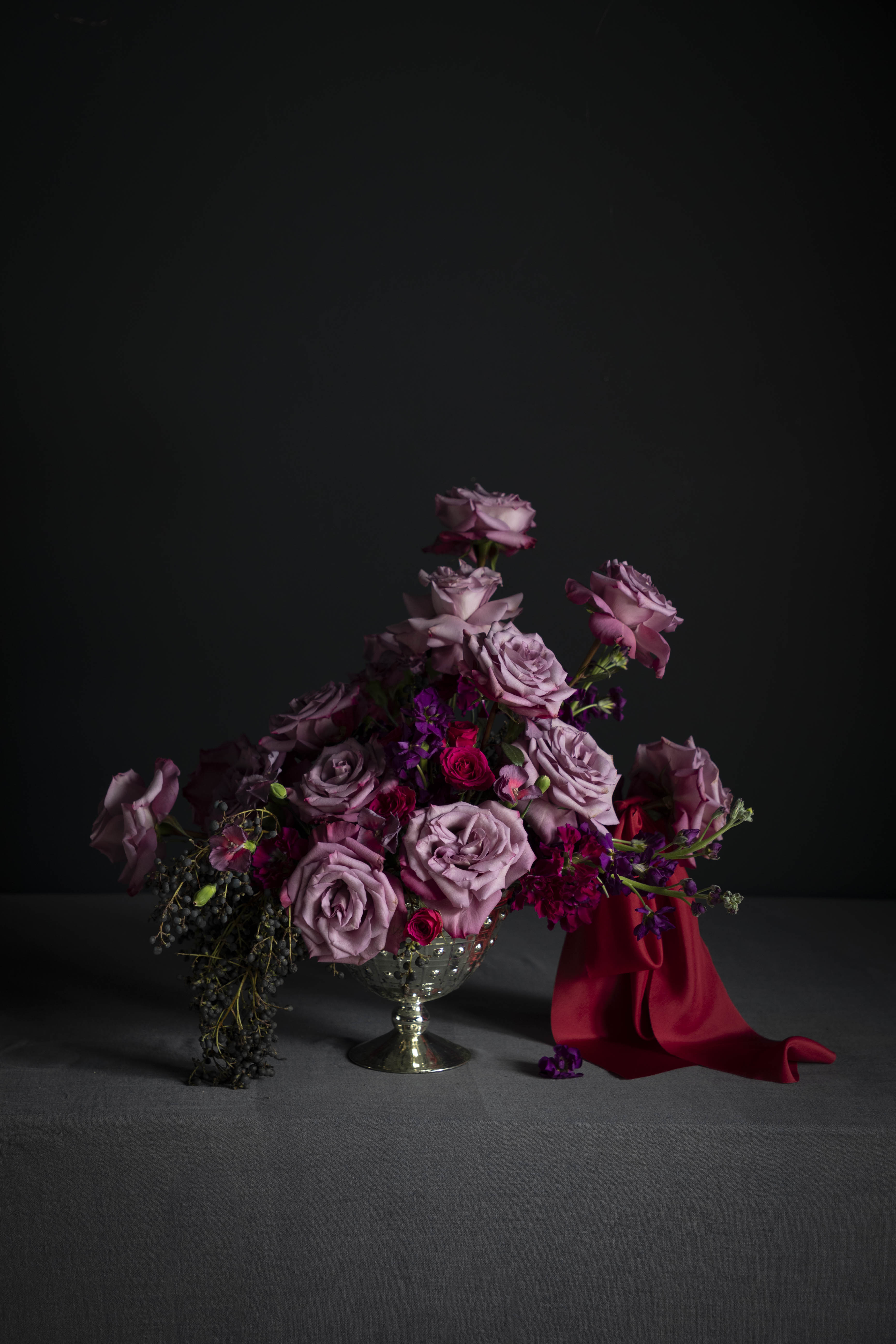 Bouquet of flowers with a red silk ribbon on a dark background