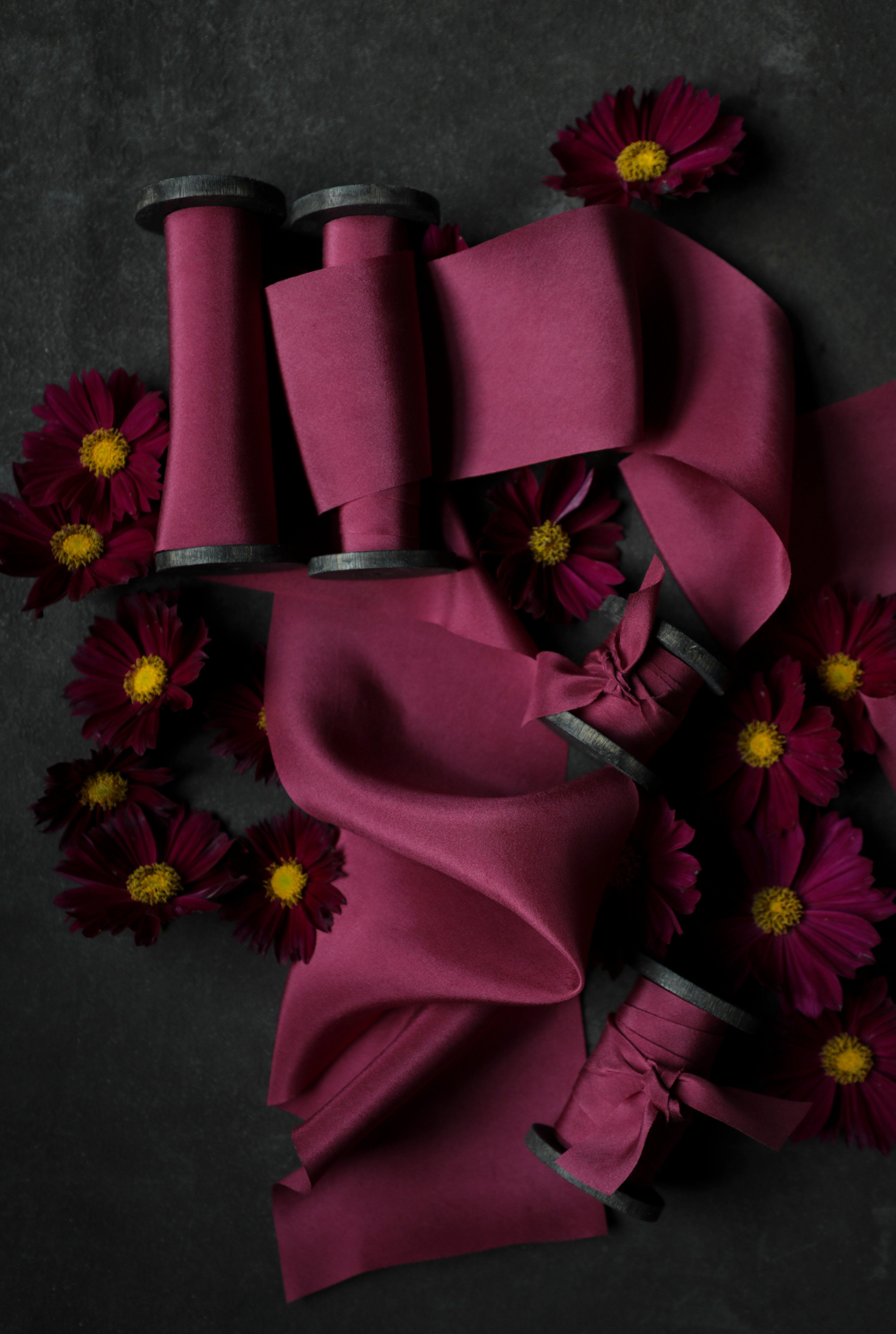Purple ribbons on spools with purple flowers on a dark background