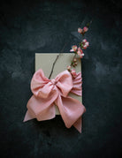 Pink bow and floral branch on a dark textured background