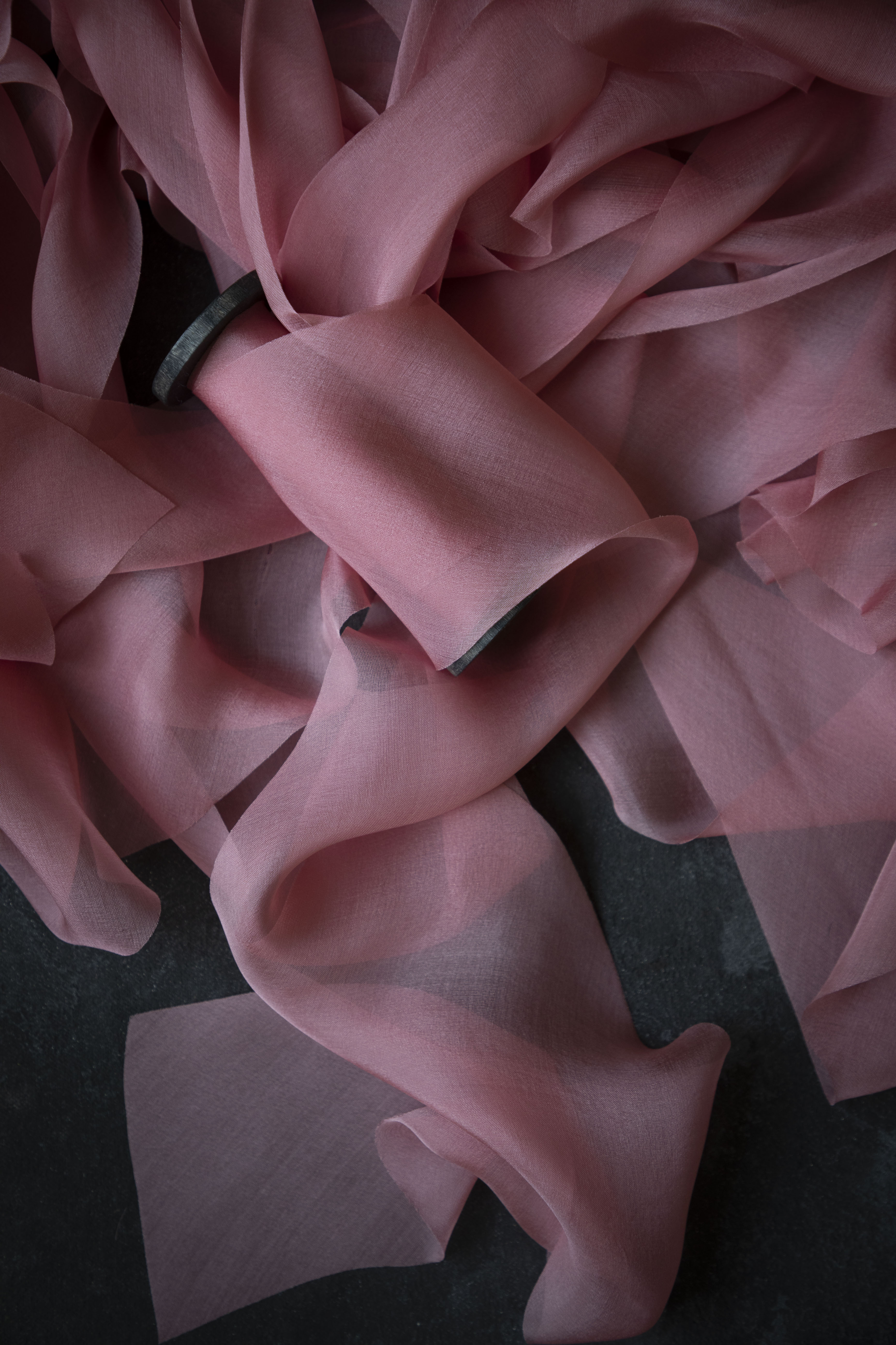Close-up of pink ribbon with ruffled texture on a dark background